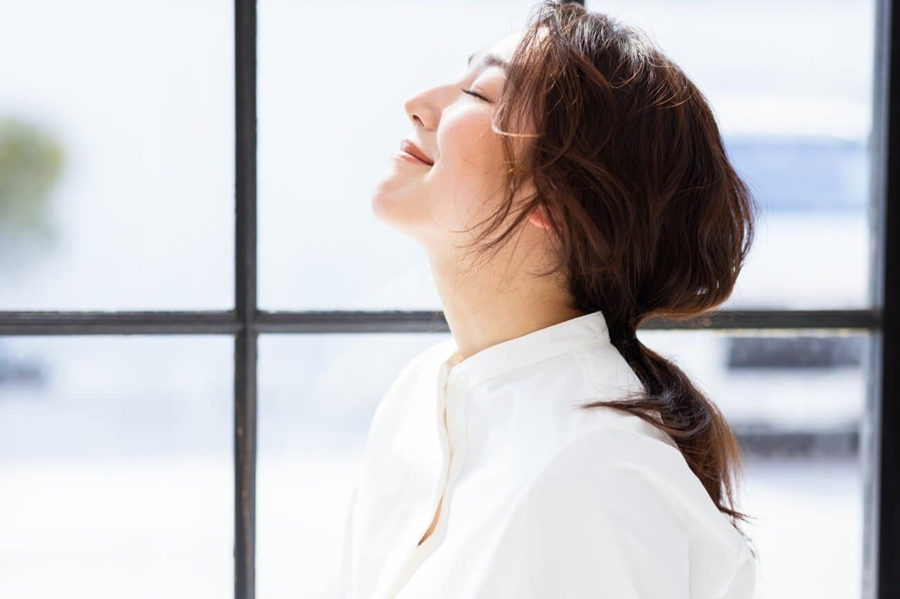 顔を上向きにした女性が目をつぶっている様子