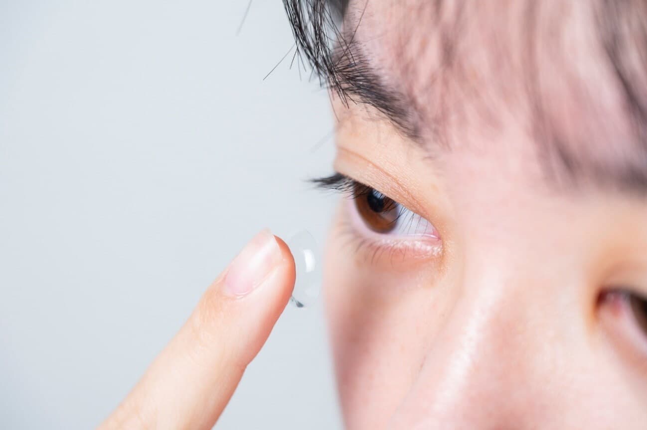 コンタクトレンズを付け外ししようとしている女性の写真